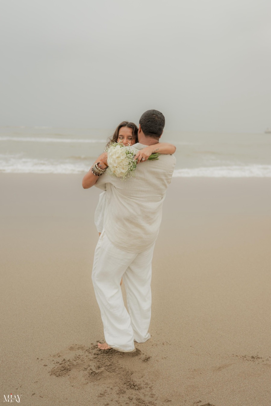 Viren lifting Pooja into a hug on the beach